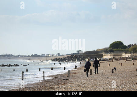 Besucher und Bewohner spazieren an einem sonnigen Wintertag am Bognor Beach, West Sussex, Großbritannien. Umfasst Hundewanderer, Jogger und Fischer. Stockfoto