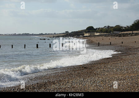 Blick auf den einsamen Strand Bognor, Südengland, an einem sonnigen Wintertag. Zeigt hölzerne Wellenbrecherstrukturen, die zur Vermeidung von Küstenerosion installiert sind. Stockfoto