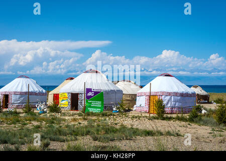 KYZYL TOO, KIRGISISTAN - 8. AUGUST: Jurten neben dem Karakol See mit der Werbung für lokale mobile Datenanbieter. August 2016 Stockfoto