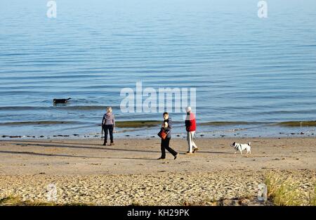 Menschen zu Fuß auf Studland Bay Strand im Herbst Sonne Dorset England uk Stockfoto