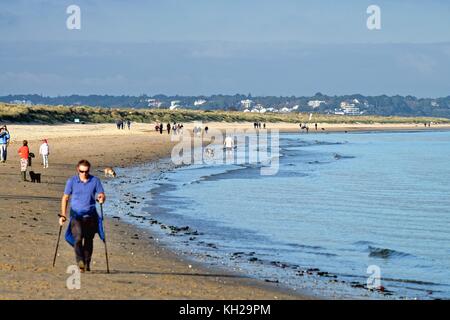 Menschen zu Fuß auf Studland Bay Strand im Herbst Sonne Dorset England uk Stockfoto