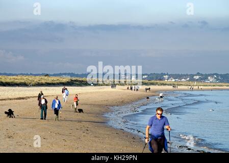 Menschen zu Fuß auf Studland Bay Strand im Herbst Sonne Dorset England uk Stockfoto