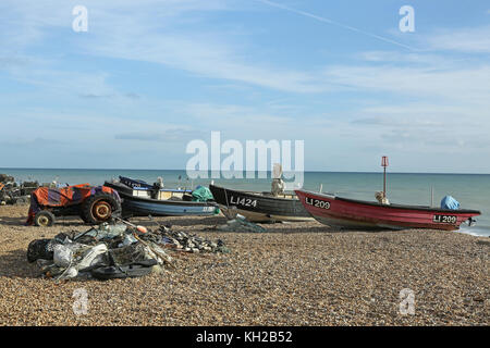 Offene Fischerboote wurden auf dem Kiesel des Bognor Beach, West Sussex, Großbritannien, hochgezogen. Zeigt Netze und Hummertöpfe im Vordergrund Stockfoto