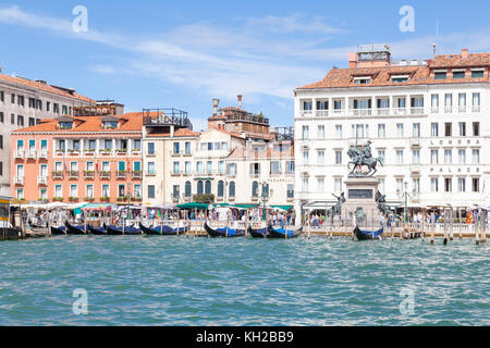 Riva degli Schiavoni und Victor Emmanuel II Monument, Castello, Venedig, Italien, gesehen von der Lagune mit einer Reihe von Gondeln. Londra Palace Savoia Stockfoto