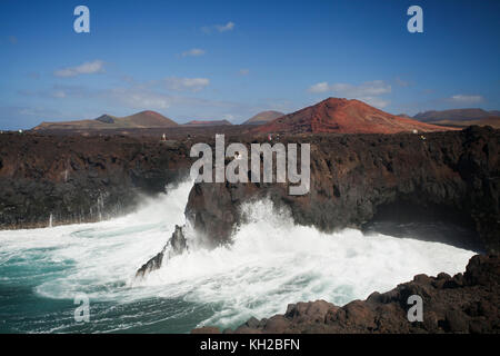 Touristen auf einem Balkon in Los Hervideros mit großen Wellen gegen Felsen, Klippen und Höhlen, Lanzarote, Kanarische Inseln, Spanien Stockfoto