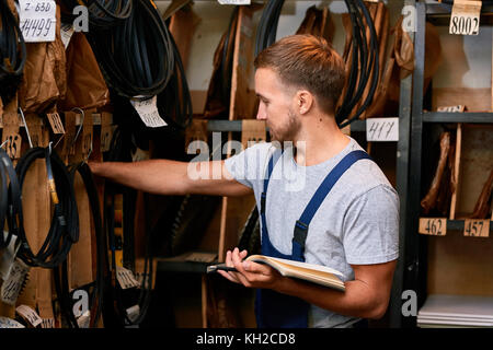 Seitenansicht Porträt der jungen Mechaniker Prüfung bestand dabei bestand in der industriellen Tools Store Stockfoto