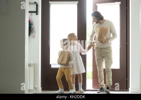 Gerne Vater mit Kindern zurück nach Hause kommen, die Papiertüte, kleinen Sohn helfen, Vati, Pakete zu der Rückkehr von store Markt, Papa und tragen Kinder aft Stockfoto