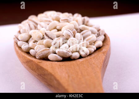 Close-up Perlen von Gerste auf einem Löffel aus Holz. Stockfoto