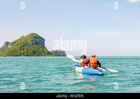 Zwei Frauen sind Mutter und Tochter. Reisen mit dem Boot mit einem Kajak gerne unter dem blauen Himmel Sommer rund um Ko Phi die schöne Natur der Meerblick und Stockfoto