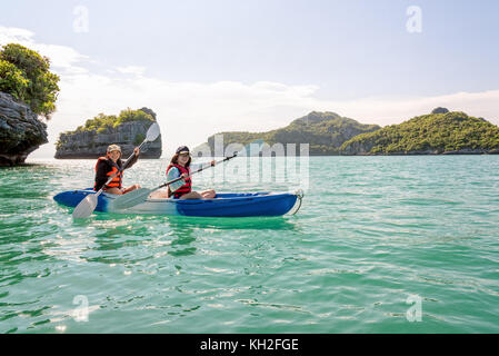 Zwei Frauen sind Mutter und Tochter. Reisen mit dem Boot mit einem Kajak gerne unter dem blauen Himmel Sommer rund um Ko Phi die schöne Natur der Meerblick und Stockfoto