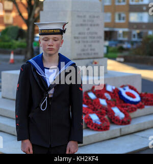 Brighton & Hove, Großbritannien, 12. November 2017 Kranzniederlegung auf das Gedenken Sonntag am Kriegerdenkmal auf Grand Avenue, Hove. Eine Parade zu einem Dienst an Allerheiligen Kirche statt follwed neben. Ein Mitglied der Sea Cadet Corps steht neben der Gedenkstätte. Credit: Clive Jones/alamy leben Nachrichten Stockfoto