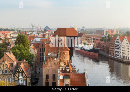 Die alten Bauten und der Kran bei der Stadt (Altstadt) und Fluss Mottlau in Danzig, Polen, gesehen von oben in den Morgen. Stockfoto