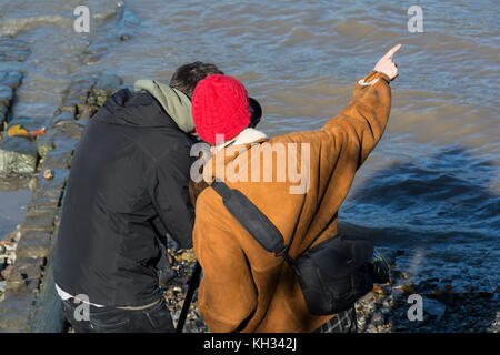 Zwei junge Fotografen in lebhaftes Gespräch auf der Themse Vorland, London, UK. Stockfoto