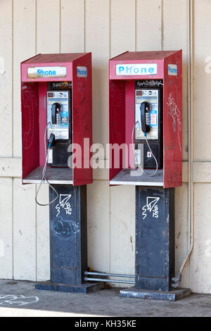 Abgebrochene Münzautomaten öffentlicher Telefone mit Münze release Slot, Graffiti. Stockfoto