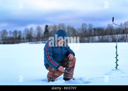 älterer Mann Angeln im Winter auf dem See Stockfoto