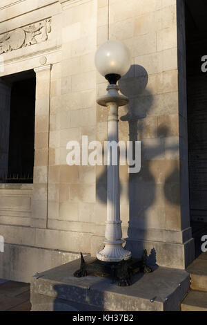 Gusseiserne Lampe Standard mit geriffelter Säule und Glaskugel, montiert auf Steinsockel vor portland Stein Kriegsdenkmal in southport lancashire uk Stockfoto