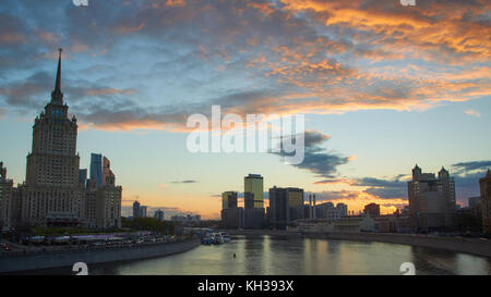 Stadtbild bei Sonnenuntergang mit den farbigen Wolken und tourboat Datenverkehr auf der Moskwa. moderne Bürogebäude im Hintergrund. Stockfoto