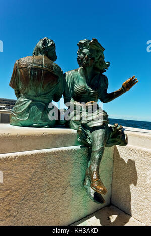 Le Sartine Bronze Skulptur, die Strick Mädchen, am Wasser. Eines der Symbole der Stadt Triest, Italien, EU. Blauer Himmel, Kopierbereich. Stockfoto