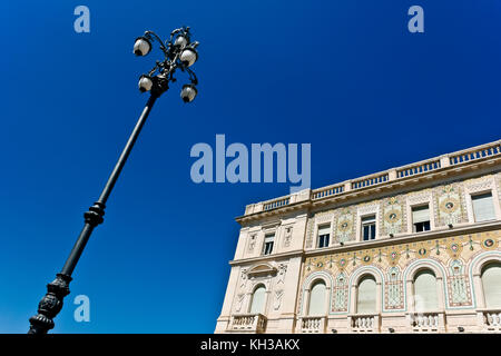 Regierungsgebäude mit Mosaikfassade, Unity Square. Palazzo del Governo, Piazza dell’Unità. Triest, Italien, Europa, EU. Lamppost. Speicherplatz kopieren. Stockfoto