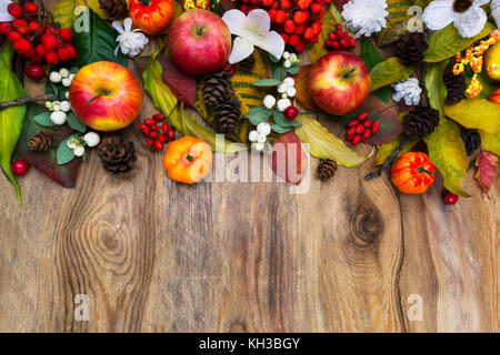 Thanksgiving oder fallen Anordnung mit Kürbisse, Äpfel, Herbstblätter, Vogelbeeren und weiße Blumen auf der rustikalen Holzmöbeln Hintergrund Kopie Raum Stockfoto