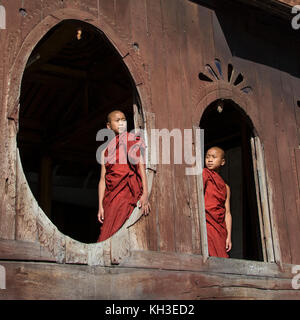 Zwei Brüder - Novizen genießen Sie die Morgensonne bei Shwe Yaunghwe Kyaung Kloster in Nyaungshwe in der Nähe Inle Lake im Staat Shan im Zentrum von Myanmar (Bur Stockfoto