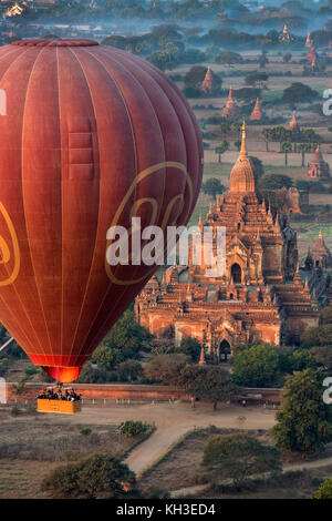Heißluftballone fliegen über die Tempel von der archäologischen Zone in Bagan am frühen Morgen die Sonne. Der Tempel im Vordergrund das Sulama Stockfoto