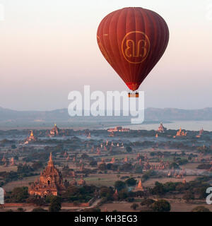 Heißluftballon fliegen über die Tempel von der archäologischen Zone in Bagan am frühen Morgen die Sonne. In der Ferne ist der Irrawaddy Fluss. Mya Stockfoto