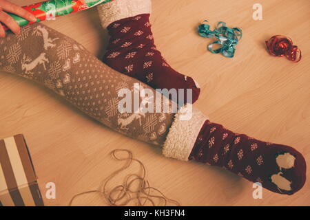 Geschenkverpackung und Weihnachtsvorbereitungen in roten Socken closeup Stockfoto