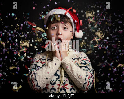 Überrascht Kind in Silvester auf schwarzem Hintergrund Stockfoto