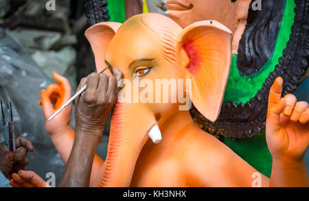 Ein Handwerker den letzten Schliff an Lord Ganesha Idol vor Beginn der festlichen Jahreszeit an kumartuli Bereich von Kolkata, Indien. Stockfoto