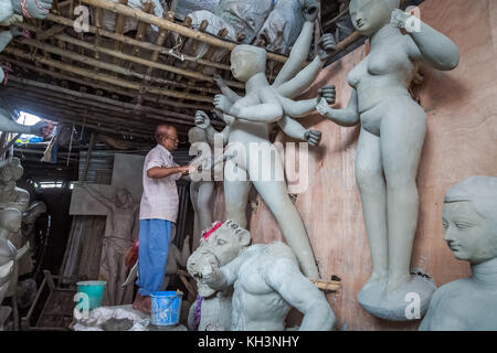 Ein Handwerker arbeitet in seinem Studio auf eine unmöblierte Durga Idol an kumartuli Bereich von Kolkata, Indien. Stockfoto