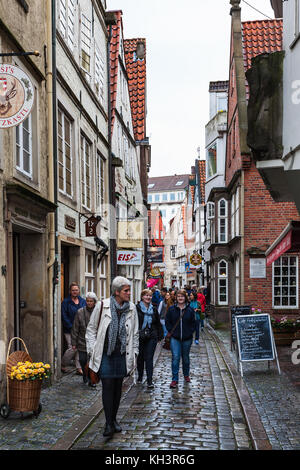 BREMEN, DEUTSCHLAND - 16. SEPTEMBER 2017: Besucher auf der engen Gasse im Schnoor-Viertel bei Regen. Schnoor ist ein Stadtteil im mittelalterlichen Zentrum der Bremer Stadt Stockfoto