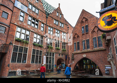 BREMEN, DEUTSCHLAND - 16. SEPTEMBER 2017: Touristen in der Nähe des Glockenspiel-Hauses in der Bottscherstraße in Bremen bei Herbstregen. Es ist die Straße im Histo Stockfoto