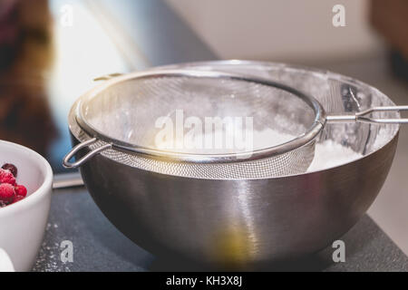 Koch Mixe und Siebe Mandel- Pulver in Mehl in die makronen Rezept Stockfoto