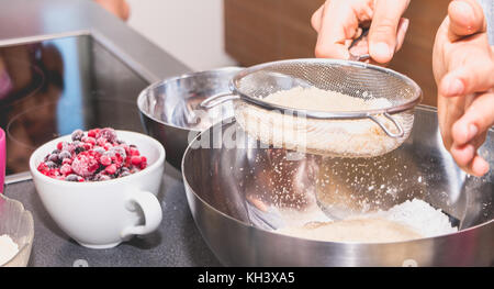 Koch Mixe und Siebe Mandel- Pulver in Mehl in die makronen Rezept Stockfoto