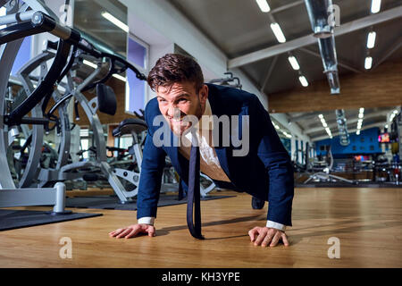 Unternehmer tun Push-ups in der Turnhalle. Stockfoto