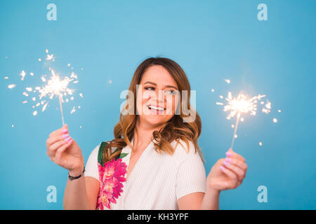 Portrait eines glücklichen Frau mit bengalischen Lichter über blauen Hintergrund. Weihnachten, Feste und Feiertage Konzept Stockfoto