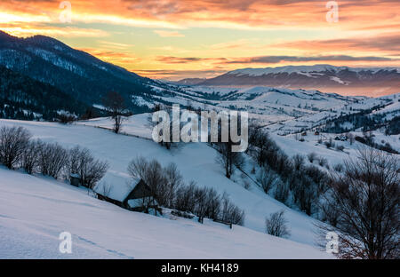 Winter Dawn in bergiger Landschaft. Wunderschöne bewölkter Himmel über die schneebedeckten Hügeln. breite Bergrücken in der Ferne Stockfoto