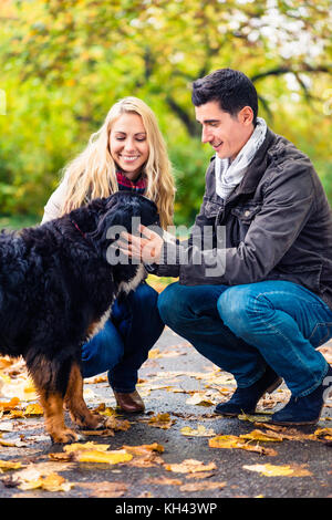 Paar mit Hund geniessen Sie den Herbst in der Natur Stockfoto