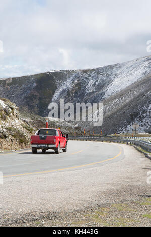 Rote Fahrzeug auf Mt Hotham Straße in leichter Schnee Stockfoto