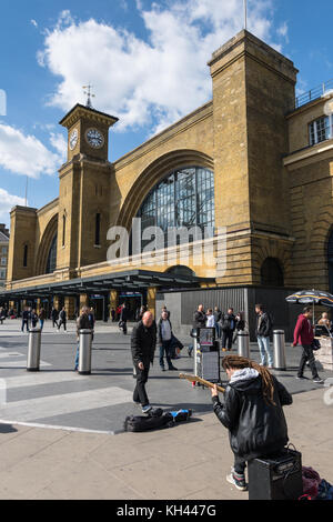 King's Cross Station London, Eingang und Platz mit Gaukler (strassenmusiker) Stockfoto