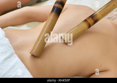 Massage mit bambusstäben. junge Frau, Bambus Massage im Spa Salon. Anti stress massage mit Bambus. Stockfoto