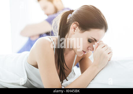 Junges Paar im Schlafzimmer in Beziehung Schwierigkeiten und argumentiert, die Frau weint Stockfoto