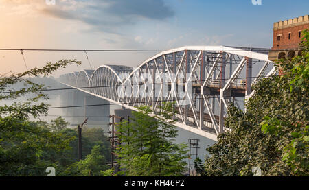 Rajghat Brücke in der Nähe von Varanasi am Ganges bei Sonnenaufgang. Ein Double Decker Brücke mit den Schienen auf der unteren Stufe und Probefahrt auf der Oberen. Stockfoto