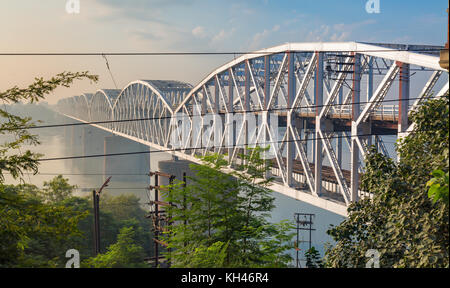 Rajghat Brücke in der Nähe von Varanasi am Ganges bei Sonnenaufgang. Ein Double Decker Brücke mit den Schienen auf der unteren Stufe und Probefahrt auf der Oberen. Stockfoto