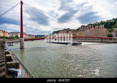 Ein Lastkahn vorbei unter dem Gateway Gerichtsgebäude Fußgängerbrücke, Lyon, Frankreich Stockfoto