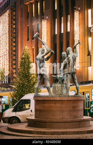 Helsinki, Finnland - 7. Dezember 2016: Nacht Blick auf berühmte Skulptur Gruppe drei Smiths Statue in Abend oder Nacht beleuchtung. Statue zeigt drei Stockfoto