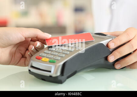 Nahaufnahme einer Frau Hand die Bezahlung mit einer kontaktlosen Kreditkarte in einem shop Counter Stockfoto