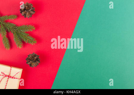 Weihnachten Zusammensetzung auf roten und grünen Hintergrund. Grüne Tanne Baum, Tannenzapfen und vorhanden, Stockfoto
