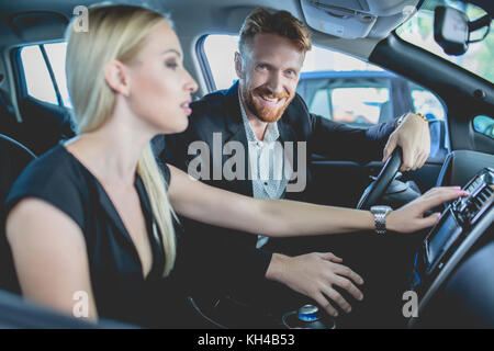 Hübsches Paar im Auto Showroom wählen Sie Auto. Stockfoto